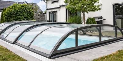 Poolüberdachung im Test: Poolabdeckung mit Halbkreisform über einem Außenpool.