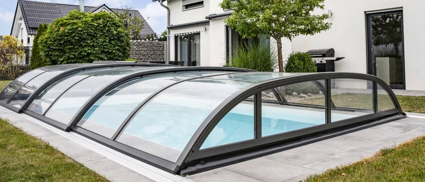 Poolüberdachung im Test: Poolabdeckung mit Halbkreisform über einem Außenpool.