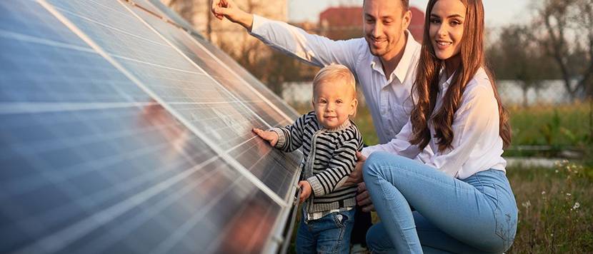 junge familie vor photovoltaik anlage
