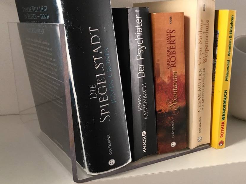 Die gebogene Plexiglasplatte dient als praktische Buchstütze.