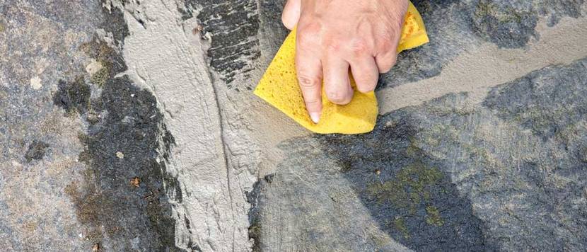 Polygonalplatten werden verfugt.