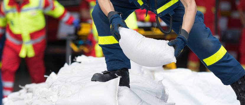 Helfer transportiert Sandsäcke