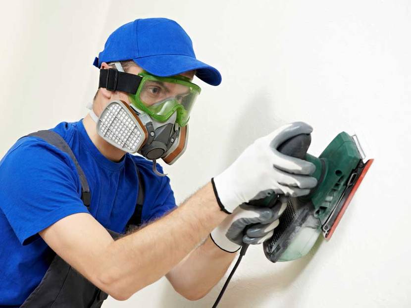 Mann schleift Wand