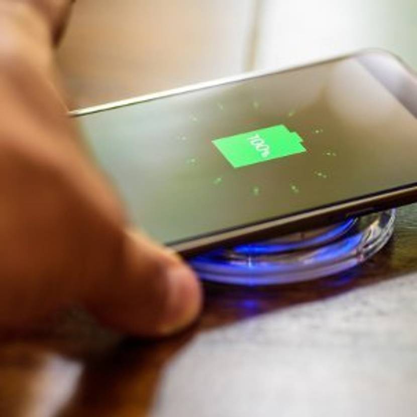Smartphone lädt auf Qi-Ladegerät.