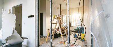 Ein Haus, in dem renoviert wird, mit offenen Wänden und Handwerker-Ausrüstung.
