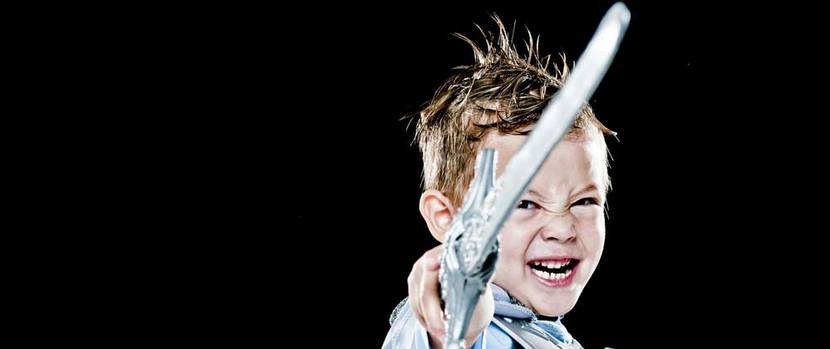 Ein Junge kämpft mit seinem Plastikschwert als Ritter verkleidet