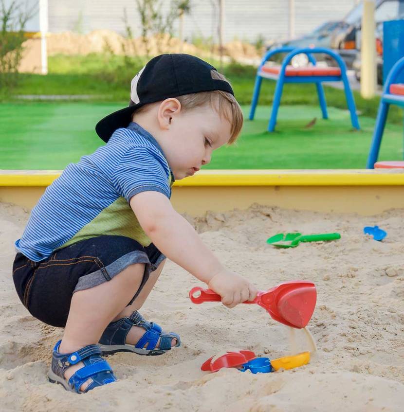 Junge spielt in gelbem Sandkasten – streichen?