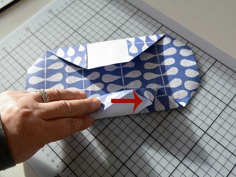 Ecken ausklappen und zur Hälfte falten.