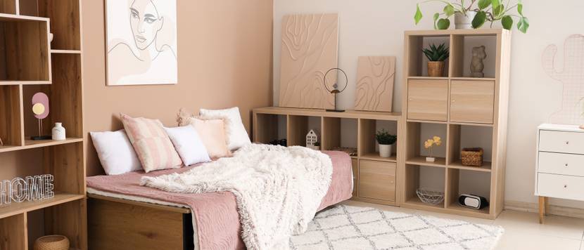 Teenager-Schlafzimmerin Rosatönen mit klappbaren Schlafsofa und Regalen.