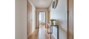 Schmaler, heller Flur in einer Wohnung mit Blick aufs Esszimmer.