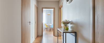 Schmaler, heller Flur in einer Wohnung mit Blick aufs Esszimmer.