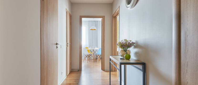 Schmaler, heller Flur in einer Wohnung mit Blick aufs Esszimmer.