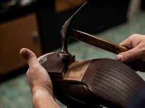 Absatz von Schuh mit Hammer reparieren