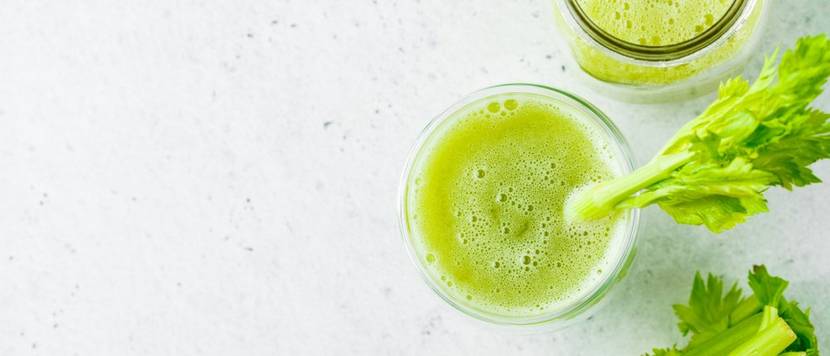 selleriesaft im glas vor weissem hintergrund