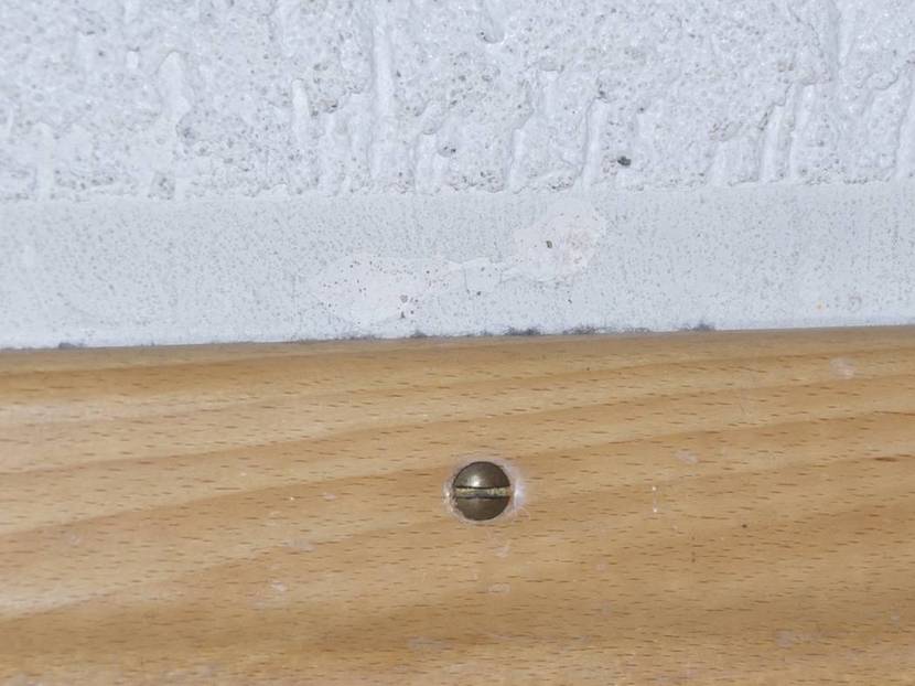 Schraube in Sockelleiste