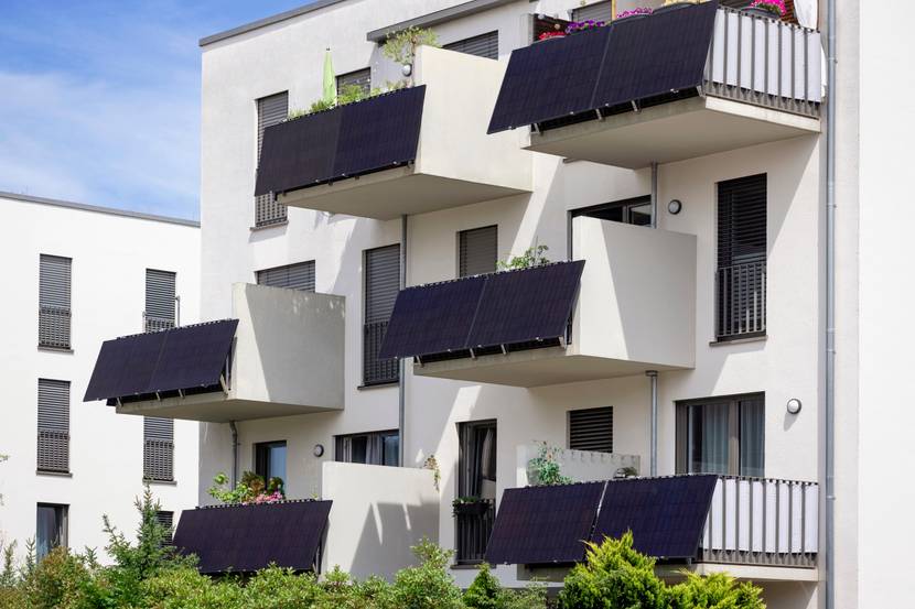 Ein Apartment-Gebäude mit Solarpaneelen an den Balkonen.