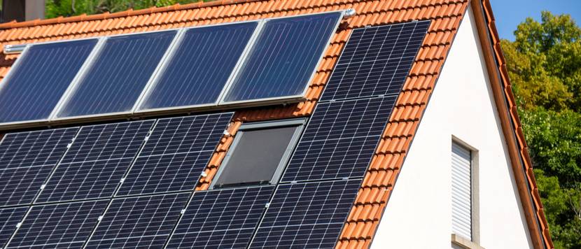 Weißes Haus mit Solarthermieanlage.