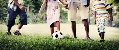 Familie mit Fußball auf Rasen