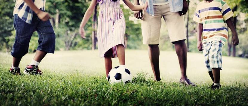 Familie mit Fußball auf Rasen