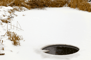 gefrorener Teich mit Loch