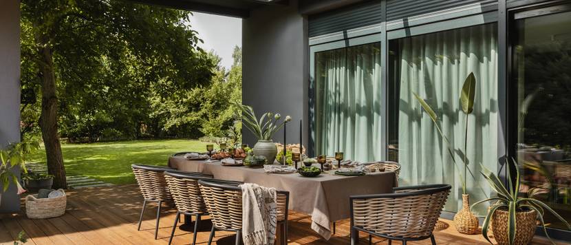 Überdachte Terrasse mit dekoriertem Tisch.