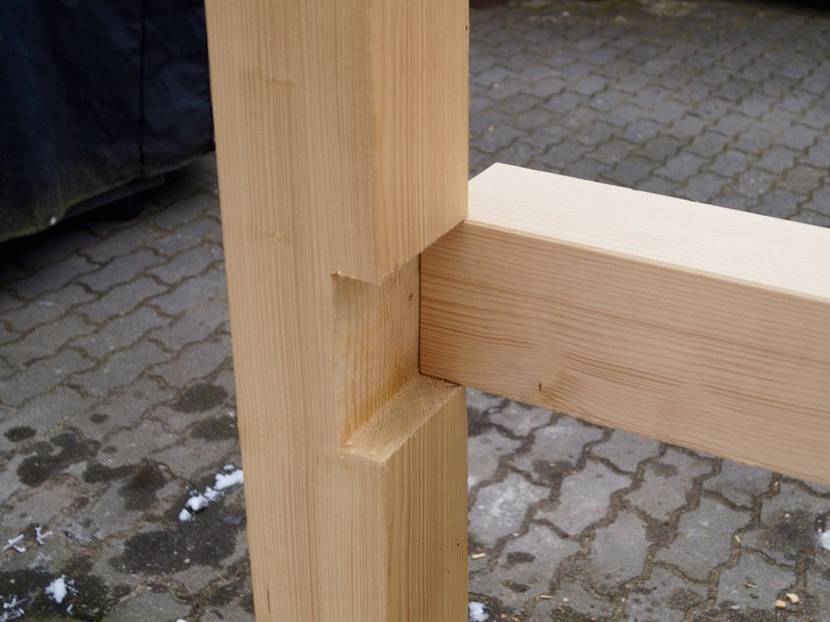 Längsbalken von beiden Seiten in die Holznut schieben.