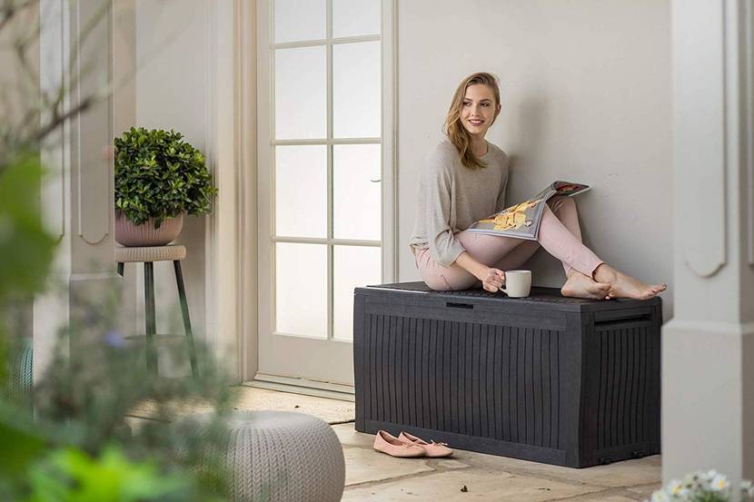 frau sitzt auf auflagenbox