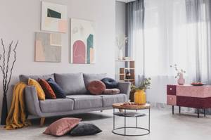 graues sofa im wohnzimmer dekoriert mit decken und kissen