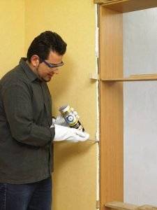 Die Dose mit PU-Schaum wird nach Herstellerangabe gründlich geschüttelt, dann spritzt man den Schaum in die Lücke zwischen den seitlichen Zargenteilen und der Wand.